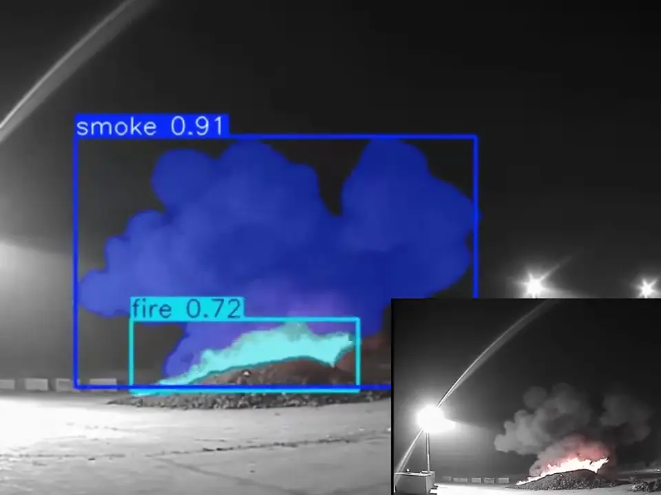 Real night-time infrared CCTV frame of a waste stockpile with smoke and flame, boxed and labelled smoke and fire by Woodcock AI