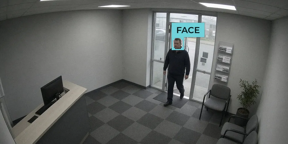 CCTV view of an office reception with a man walking in through the glass entrance door